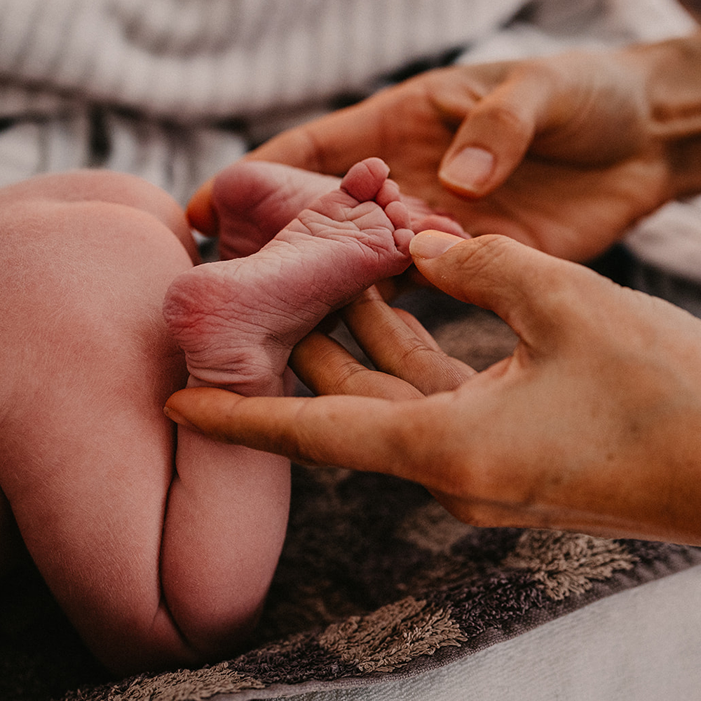 Hebamme zählt Zehen des Babys Geburtsfotografie Shalynn Crawford Tübingen